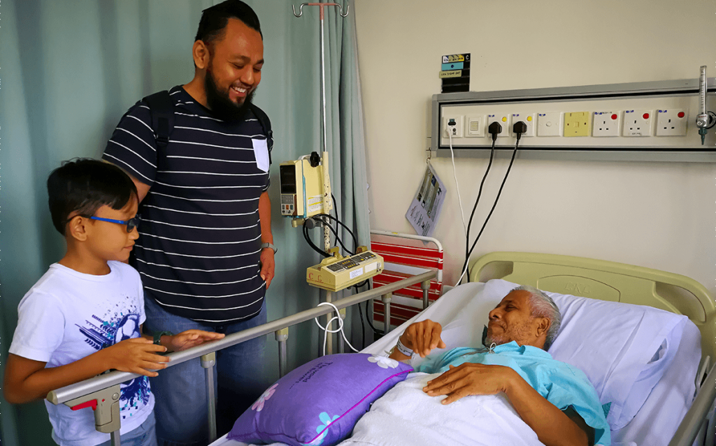 man and son with older man at hospital